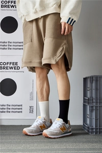 Street style outfit with khaki cargo shorts, beige sweatshirt, and mid-calf crew socks