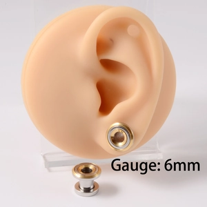 Detailed view of 6mm stainless steel ear gauge expander on professional ear model