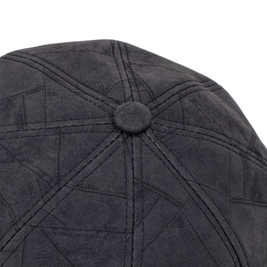 Detail of dark grey suede octagonal hat showing geometric stitching and texture