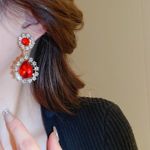 Détail de boucles d'oreilles vintage en forme de fleur et goutte avec cristaux rouges