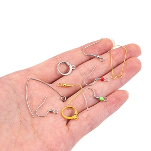 DIY jewelry earring findings in gold and silver finish shown on hand for scale