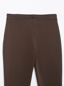 Detail of high-waist dark brown leisure pants featuring elastic seams and knit texture