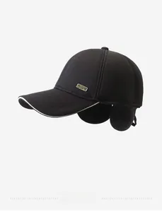 Detail of winter baseball cap featuring fold-down ear flaps and metal logo badge