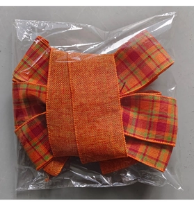 Close-up of an orange plaid bow decoration made of burlap fabric in clear packaging