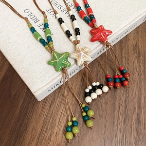 Detail shot of ceramic starfish necklaces with colorful beads and braided wax ropes