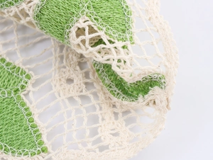 Gros plan détaillé de cercles au crochet verts avec maille ajourée beige texturée
