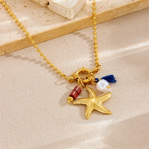 Gold beaded chain necklace featuring starfish, baroque pearl, and blue tassel charms
