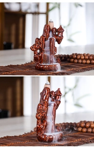 Macro shot of mountain ceramic backflow incense burner with smoke flowing down like a waterfall