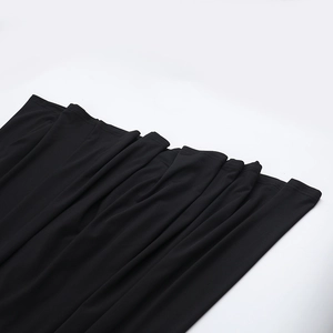 Détail de la robe noire élégante montrant les plis du tissu et la texture de qualité