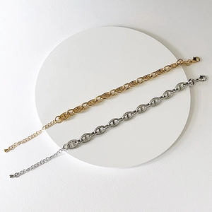 Macro detail of gold and silver pig nose link bracelets with adjustable lobster clasp