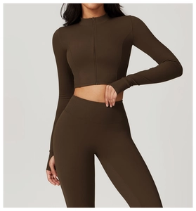 Détail d'une veste de yoga ajustée avec passe-pouces et legging de fitness taille haute