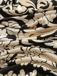 Macro view of high-quality silk satin fabric with elegant floral print and luxury luster