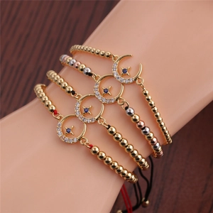 Detail of four-piece gold celestial beaded bracelet set with moon and star zircon charms