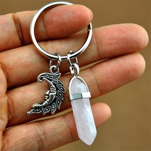 Detail of pink crystal hexagonal pillar and silver crescent moon face pendant keychain