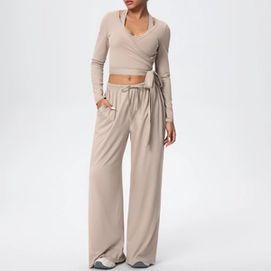 Détail du pantalon à cordon taille haute et du haut court croisé en maille beige doux