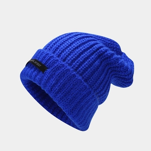 Detalle de gorro de punto azul con textura acanalada y etiqueta de tela negra lateral
