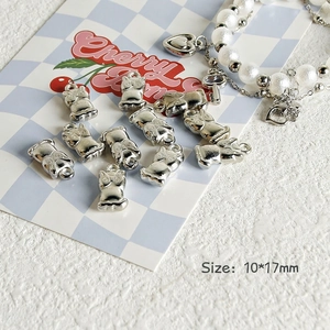 Silver cat and owl charms shown with a white pearl heart bracelet for DIY jewelry making