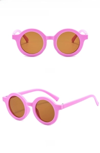 Detail view of pink round frame kids sunglasses with brown UV400 protective lenses