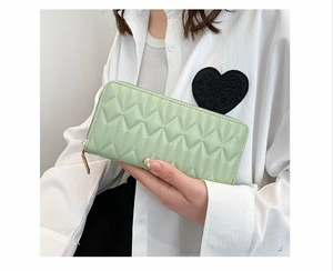 Detailed close-up of a light green quilted PU leather wallet for women with golden zipper