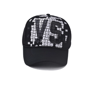 Detail of a black trucker hat featuring a 3D printed VS logo with puzzle pattern
