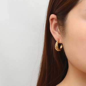 Orecchini a cerchio croissant in acciaio placcato oro 18K indossati da una modella