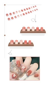 Detailed view of peach pink gradient press-on nails with 3D camellia flowers and pearls