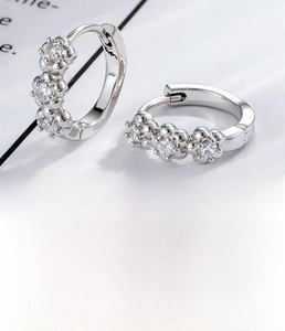 Detailed macro view of silver flower zircon earrings with 10mm inner diameter