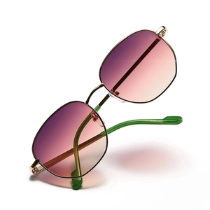 Retro round metal sunglasses with pink gradient lenses and gold frames on white background