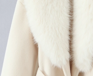 Dettaglio del soffice collo in ecopelliccia e del tessuto in lana beige del cappotto
