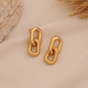 Golden textured double hoop chain earrings on beige fabric with shell and grass decor