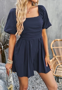 Detail of square neck romper in navy blue with puff sleeves and pleated cotton fabric