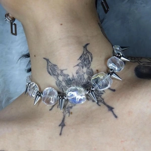 Detail shot of punk collar with transparent beads and metallic spikes on model