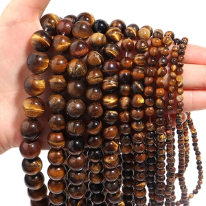 Close-up of tiger eye stone beads in various sizes for DIY jewelry making with cat-eye effect