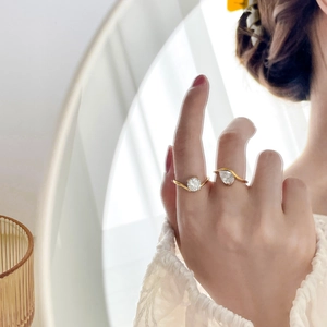 Elegant gold-plated rings with round and pear-cut cubic zirconia in curved band design