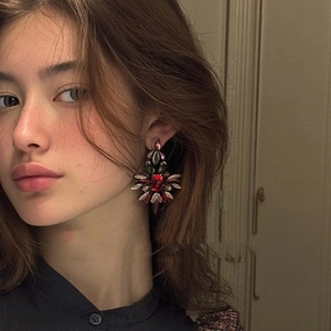 Boucles d'oreilles bohèmes avec pierre rouge rectangulaire portées par un mannequin