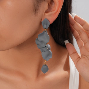 Close-up of retro grey acrylic petal tassel earrings on a model showing matte texture