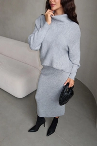 Detail of grey knitted turtleneck sweater and matching midi skirt set texture