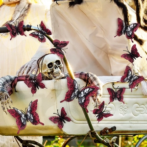 Close-up of vintage stroller with skull figure and 3D red and black butterfly stickers