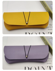 Close-up of mustard yellow and lavender PU leather eyewear cases with gold bead fastener