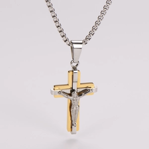 Close-up of gold and silver crucifix pendant with Jesus figure on a silver chain