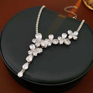 Macro shot of silver flower and water drop pendant necklace with zircon gemstones