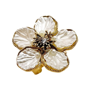 Elegant gold flower ring featuring white coral petals and a sparkling zircon center