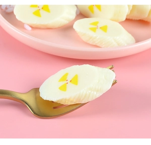 Macro detail of realistic PVC banana slice model with yellow radiation symbol on a fork