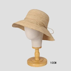 Handmade raffia straw sun hat with 10cm brim and bow detail on a display stand