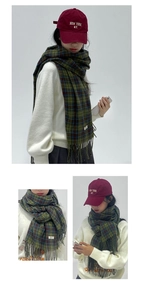 Detail of green plaid tassel scarf and red New York embroidered baseball cap combo