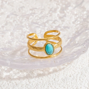 Detailed macro of a 18k gold layered open ring with an inlaid turquoise gemstone