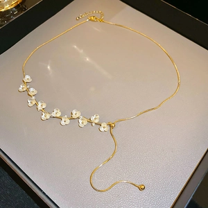 Dettaglio della collana a fiori con petali bianchi e catena placcata oro in scatola