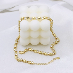 Elegant gold heart link necklace with cubic zirconia stones on white silk backdrop