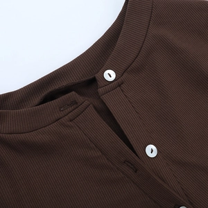 Detail of crewneck collar and white buttons on dark brown ribbed knit cardigan