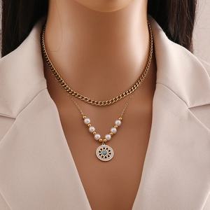 Detail of gold double-layer necklace with pearls and turquoise gemstone pendant on model
